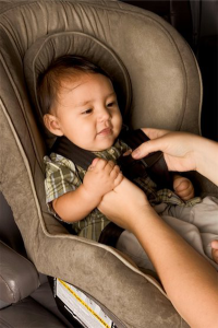 Car seats: photo of baby being fastened into car seat