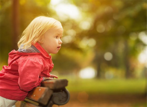 children of same-sex marriage; photo of young girl kneeling on park bench