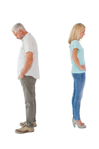 photo of man and woman standing apart with their backs to each other and heads down