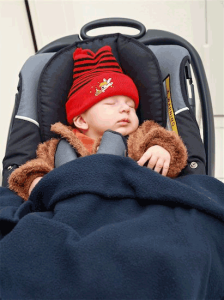 car seat safety: photo of baby dressed in heavy fur coat buckled into child safety seat