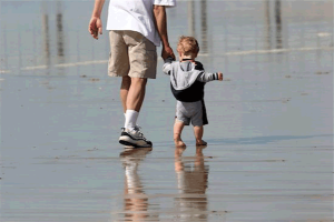 Tri-parenting custody: photo of man and child walking in water along beach