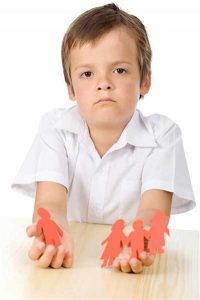 Photo of child holding cutouts of family separated by divorce