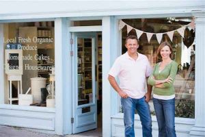 Protecting family-owned business from divorce - photo of couple standing outside storefront of grocery business