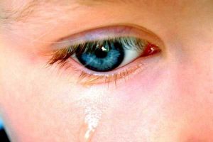 Child's blue eye with tear showing affects of domestic violence on children