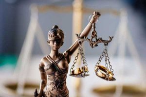 fair divorce settlement or financial fraud; Lady Justice with wedding bands in scales