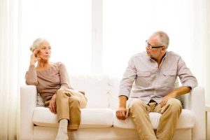 Gray Divorce - senior couple sitting on opposite ends of sofa