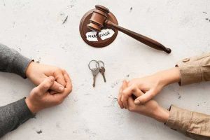 Annulment vs divorce - 2 sets of folded hands, house keys and a gavel depict couple contemplating the termination of their marriage